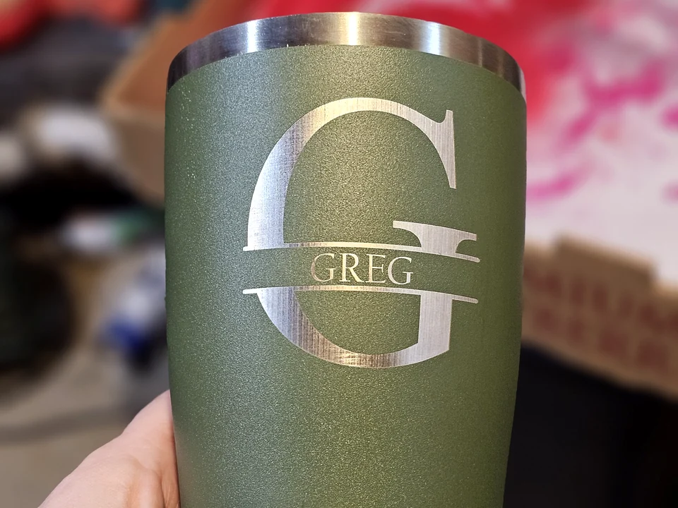 Green insulated tumbler laser engraved with a Greg monogram